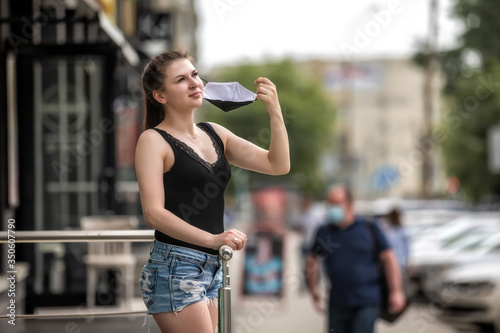 girl in the city takes off a medical mask. girl in the street takes off a medical mask. © Руслан Краюшкин