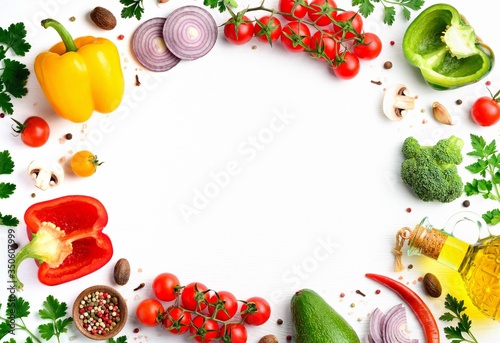Fresh vegan ingredients for homemade pizza on white wooden background. Variety vegetables, spices and herbs frame. Flat lay, top view, copyspace.