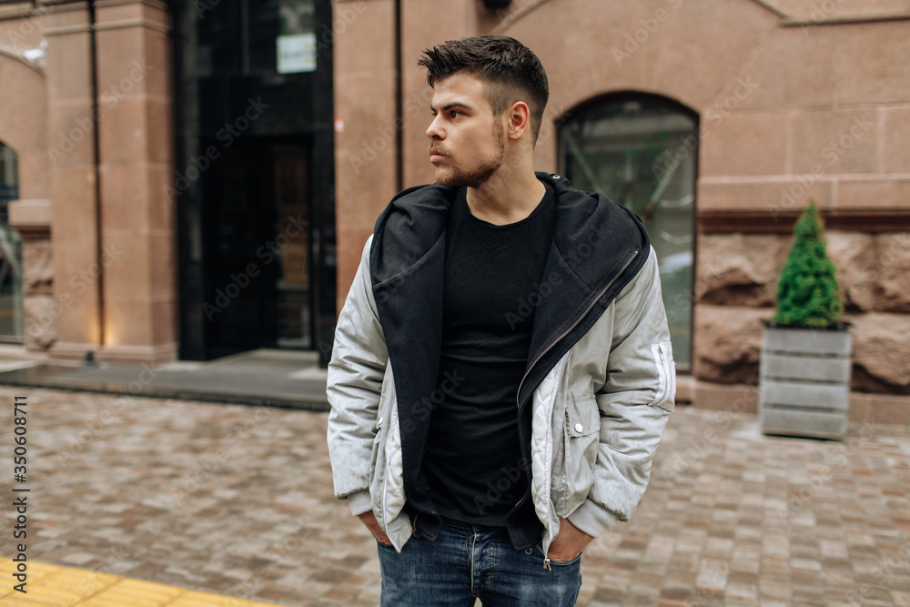 Portrait of a young man walking around the city. Brunette, beard. Cheerful, beautiful smile. Portrait of a young man walking around the city. Brunette, beard. Cheerful, beautiful smile.