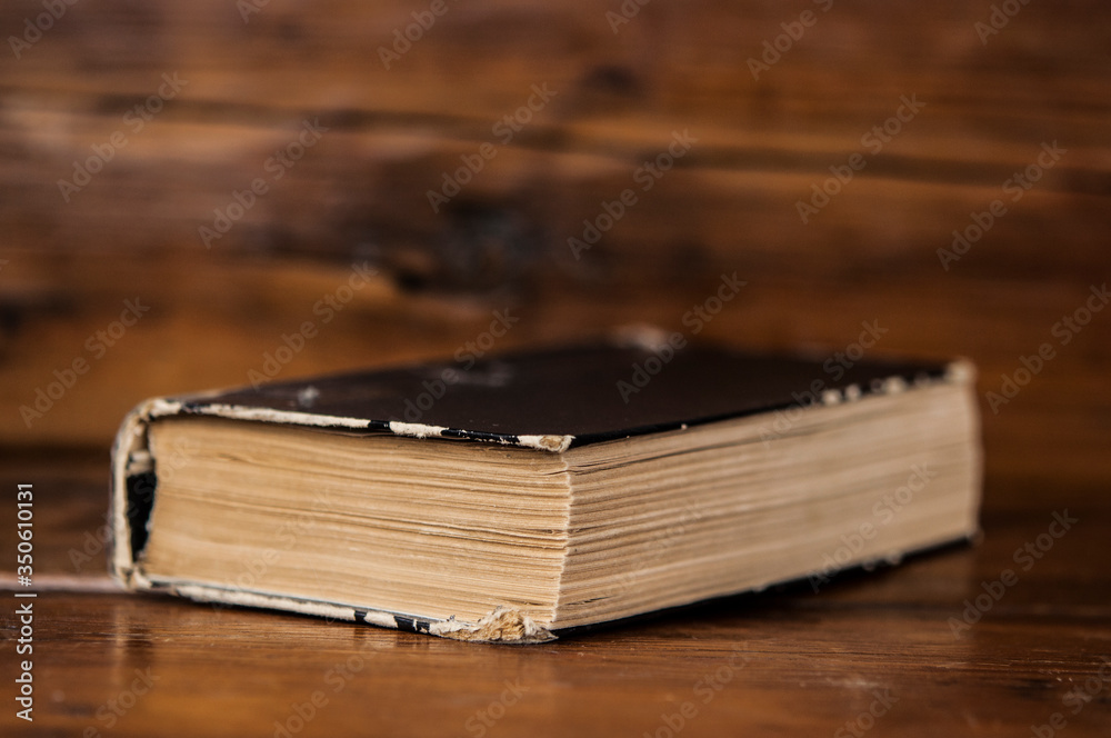 Old shabby book on a rough wooden table. Top view, copy space Old shabby book on a rough wooden table. Top view, copy space