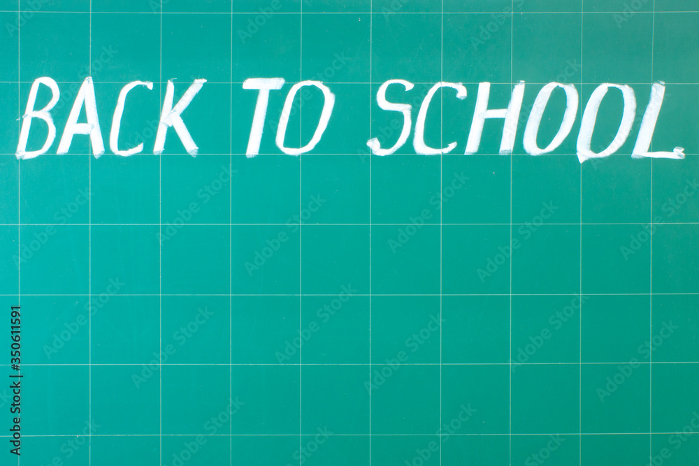 White chalk writing on a green chalkboard - back to school close-up and copy space. White chalk writing on a green chalkboard - back to school close-up and copy space.