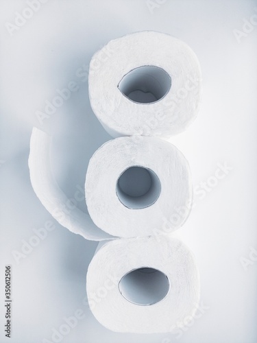 Rolls of white toilet paper on a white background.
