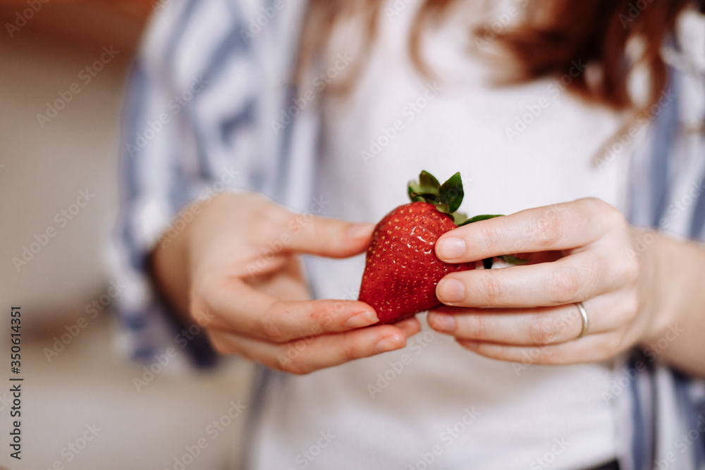 Obraz premium Juicy and fresh strawberry in women's hands.