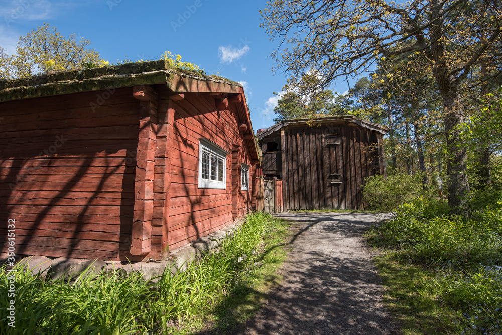 Old Falu red timber logg house in a park in Stockholm a sunny spring day Old Falu red timber logg house in a park in Stockholm a sunny spring day
