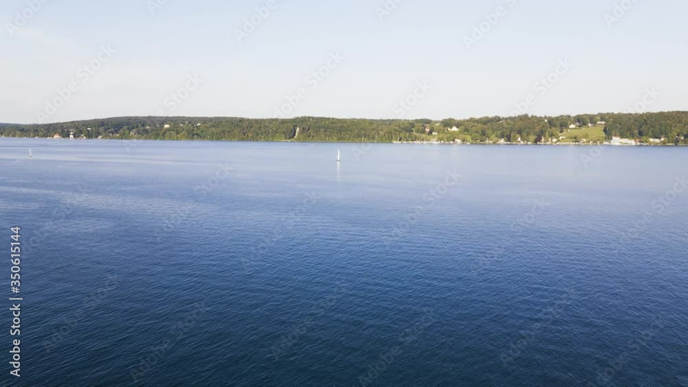 Time lapse drone flight over a wide open lake onto a sailing boat. Lake Starnberg near Munich in beautiful evening light. Sailing as a hobby Time lapse drone flight over a wide open lake onto a sailing boat. Lake Starnberg near Munich in beautiful evening light. Sailing as a hobby