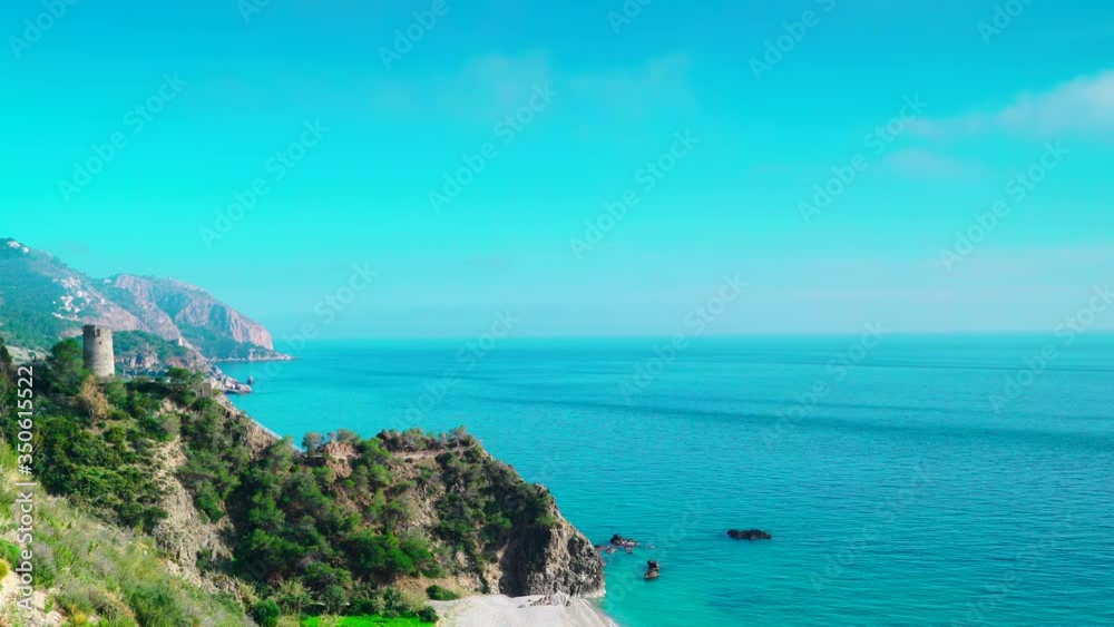 Time lapse of clouds moving over coastal landscape with watchtower. Torre Del Pino, tower on cliffs of Maro Cerro Gordo Natural Park, Malaga province, Costa Del Sol, Andalusia, Spain Time lapse of clouds moving over coastal landscape with watchtower. Torre Del Pino, tower on cliffs of Maro Cerro Gordo Natural Park, Malaga province, Costa Del Sol, Andalusia, Spain