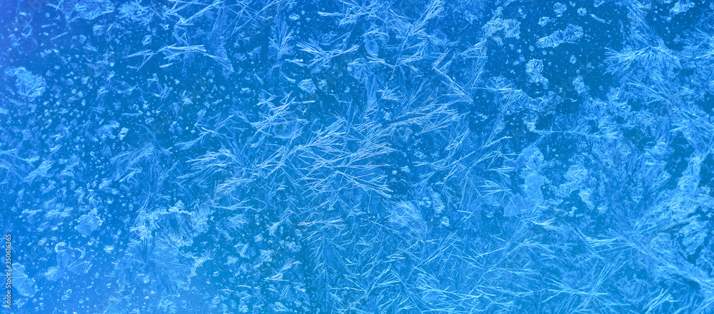 Ice flowers and frozen window macro view. Frost texture pattern. cold winter weather xmas background concept.