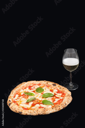  italian pizza margherita  in a black background from the top whit a glass of delicious Italian sparkling white wine called prosecco