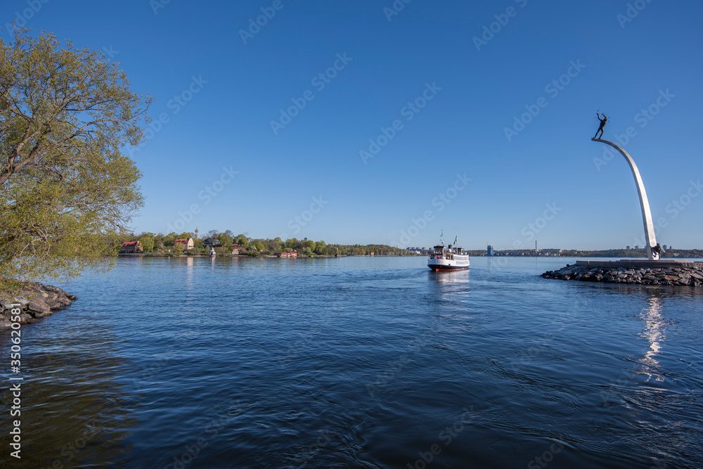 Fototapeta premium Nacka Strand harbor view with boats and monument in the district Nacka a sunny spring morning in Stockholm.