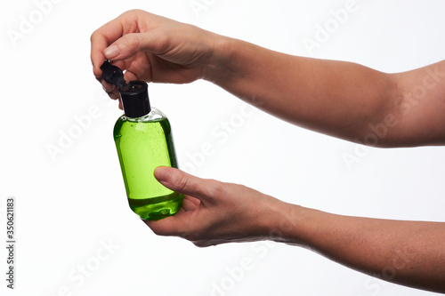 Manos abriendo frasco de gel desinfectante photo