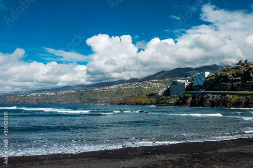 The coast of the island of Tenerife. Tourist season on a tropical island. Volcanic beaches and black sand in Spain. Rocks and rocks in the Atlantic ocean. Trekking and excursions in the Canary Islands