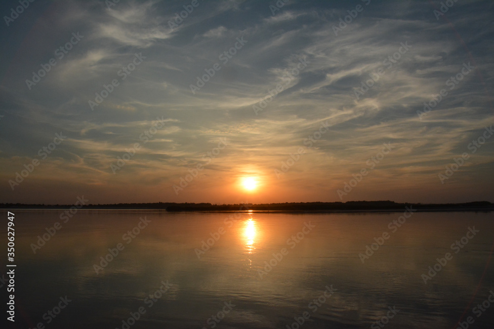 Beautiful sunset on the Volga river. 
The sun is reflected in the river. Russia.