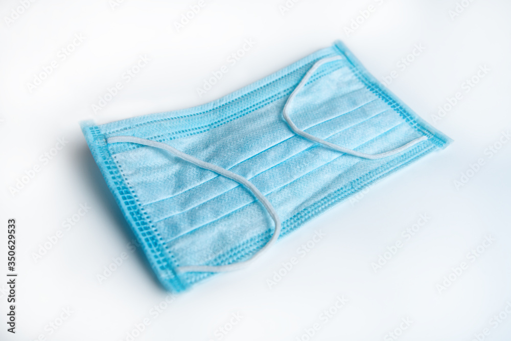 blue medical mask for protection against viruses on a white background blue medical mask for protection against viruses on a white background