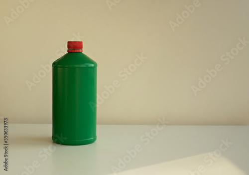 Green bottle on a light background. Space for text