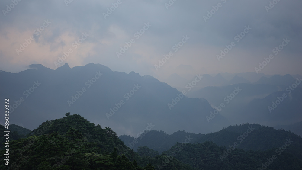 Beautiful glorious colourful sunrise in the national park over the mountains in China, mysterious landscape with hills, clouds, mist and colour shades, trekking and hiking outdoors, peak summit
