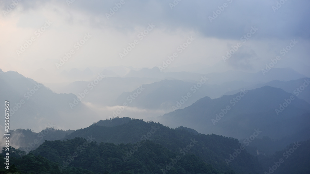 Obraz premium Beautiful glorious colourful sunrise in the national park over the mountains in China, mysterious landscape with hills, clouds, mist and colour shades, trekking and hiking outdoors, peak summit