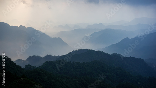 Beautiful glorious colourful sunrise in the national park over the mountains in China, mysterious landscape with hills, clouds, mist and colour shades, trekking and hiking outdoors, peak summit  © Lesia Povkh