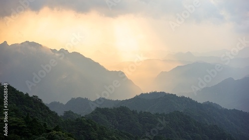 Beautiful glorious colourful sunrise in the national park over the mountains in China, mysterious landscape with hills, clouds, mist and colour shades, trekking and hiking outdoors, peak summit 