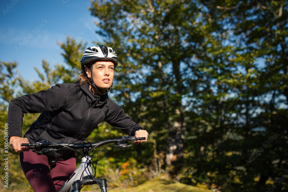 Naklejka premium Female mountain biker riding outdoor