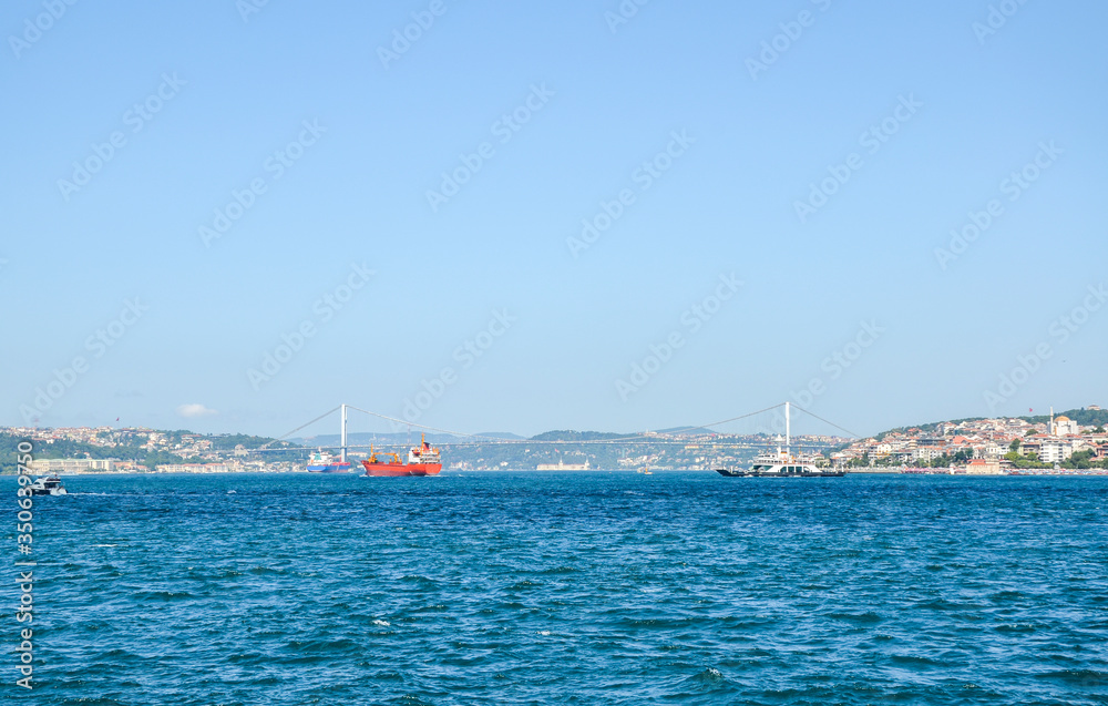 View of Bosphorus bridge from the distance across the Bosphorus strait, with a ships Istanbul, Turkey