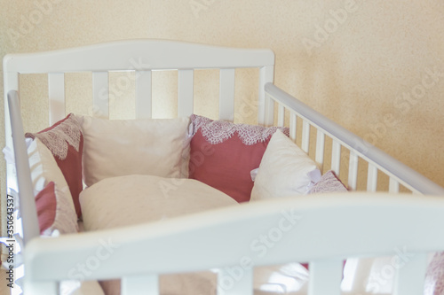 Baby bed crib with white and Burgundy color pillows with laces