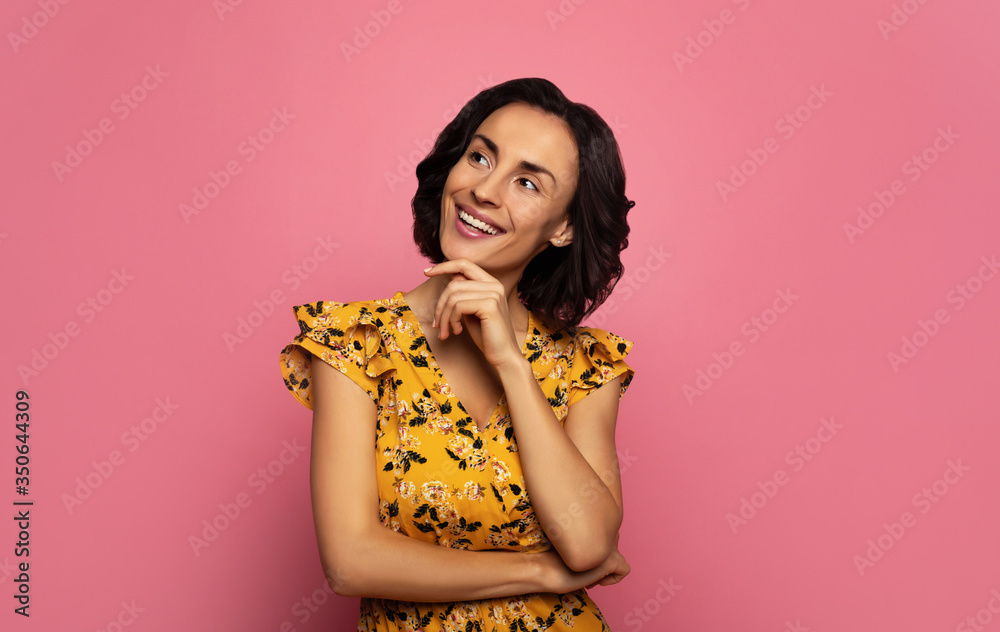 Charm. Close-up photo of attractive girl in a floral dress, who is looking to the left and smiling. Charm. Close-up photo of attractive girl in a floral dress, who is looking to the left and smiling.