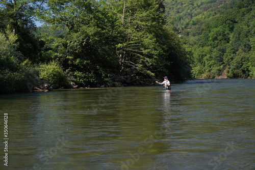 fly trout fisherman in big river