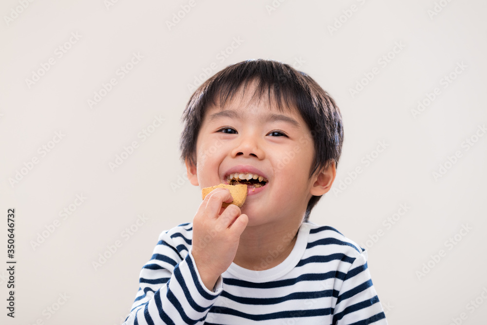 Asian kid boy eat cookie on white background Asian kid boy eat cookie on white background