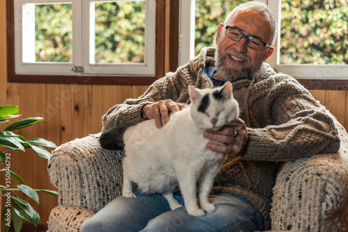 senior adult petting his cat at home photo