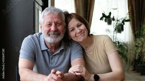 Happy senior elder father grandfather and adult grown daughter, loving two generations family embracing at home