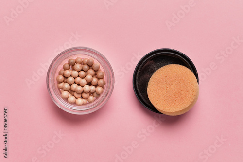 Cosmetic powder in the form of balls on a pink background. Top view.