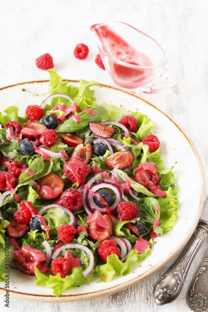 Salad with berries-raspberry, blueberry, sweet cherry. Dressed with raspberry vinaigrette. Soft focus. copy space