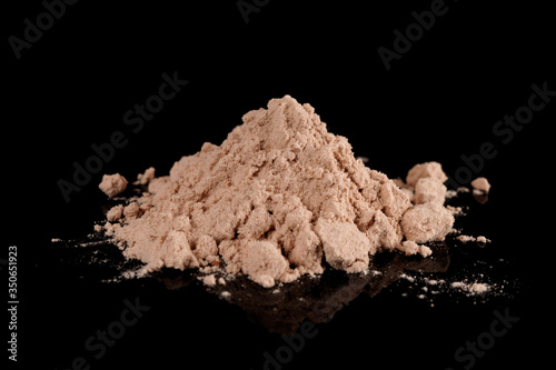 Foto Small pile of brown substance looking like heroin isolated on black