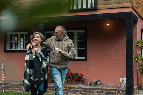 senior adult couple walking the garden of their home