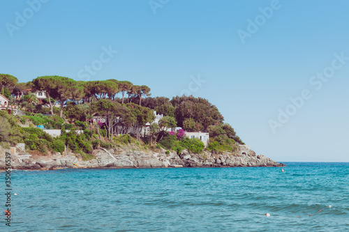 Italian maritime coast of the Island of Elba with rocky cliff ridge and perched house. Sea in Italy in the city of Procchio.