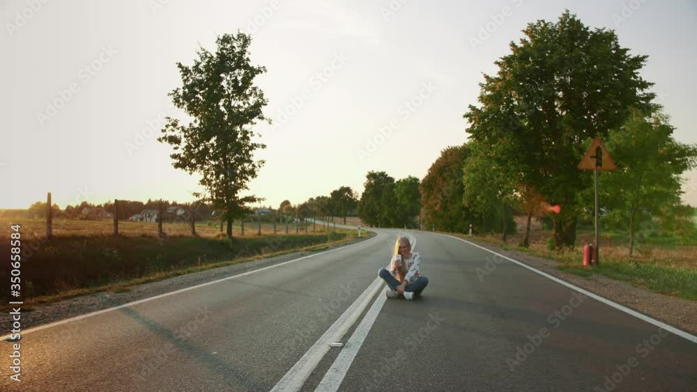 Young woman taking selfie on road. Lovely young lady smiling and posing for selfie while sitting on road in Europe countryside. 4K Young woman taking selfie on road. Lovely young lady smiling and posing for selfie while sitting on road in Europe countryside. 4K