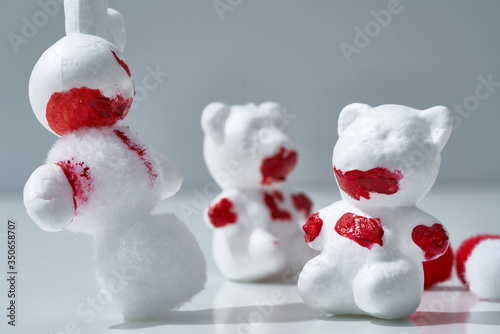 Bloody Christmas scary celebration scene, white animals, hares and bears made of plastic celebrate holiday in the forest   photo