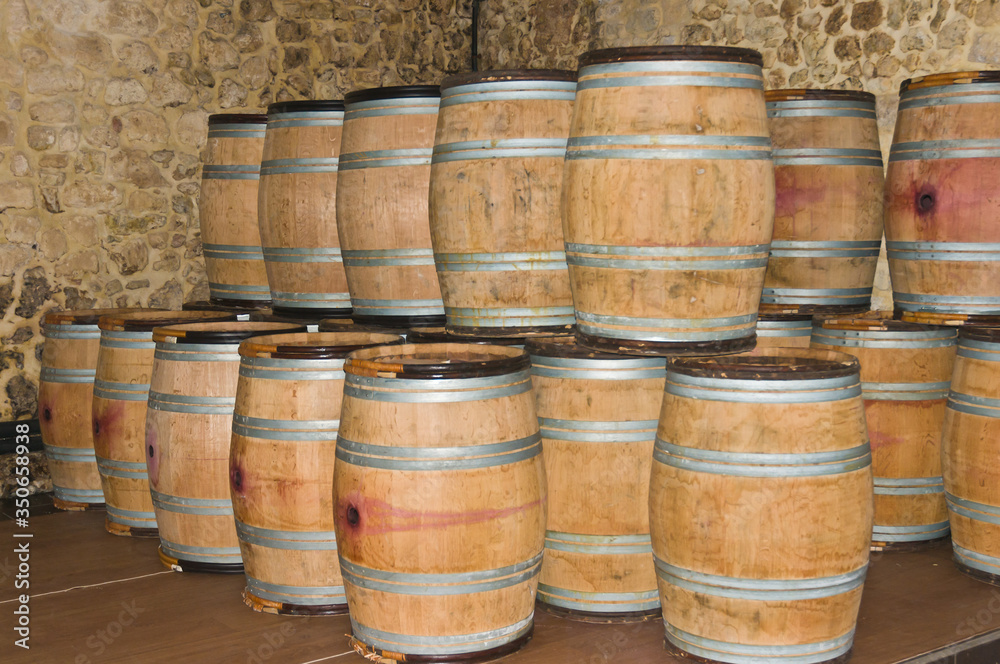 Front view, medium distance of new french oak barrels, filled with red wine and located in a winecellar in Burgundy France, will satay in temperature controlled climate for two years