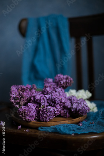 Bouquet of lilac on a dark background on a chair