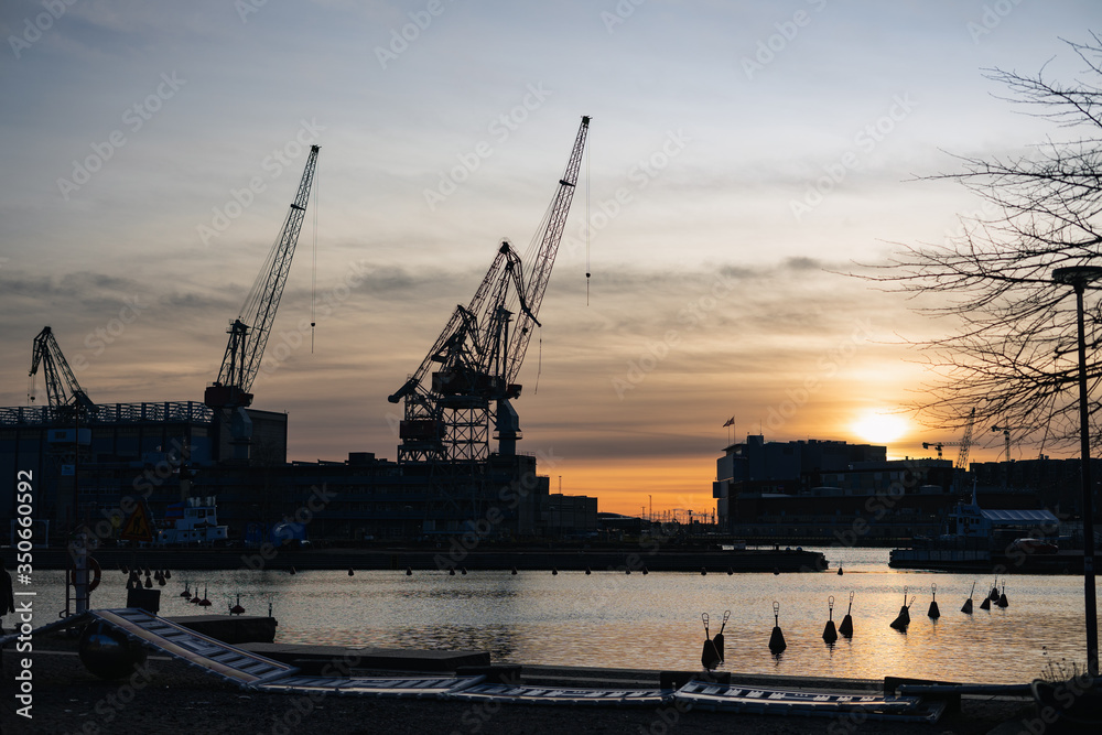 cranes in harbor, sunset