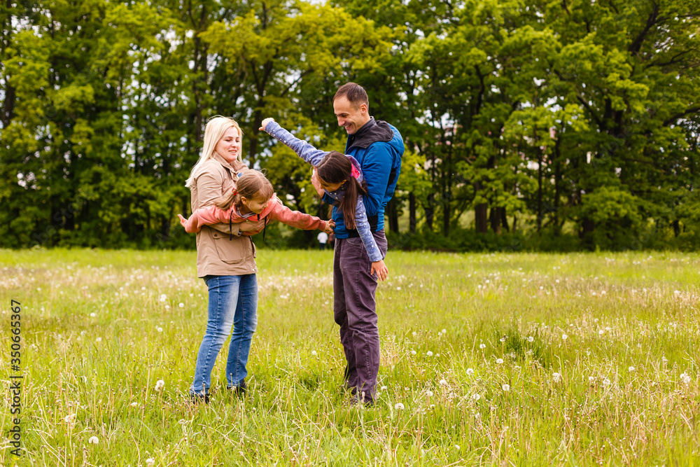 young familiy are walking through a green field young familiy are walking through a green field