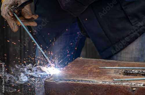 Metal welding by a manual electric welding machine.