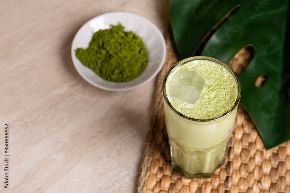 Glasses of matcha latte with coconut milk and white chocolate on marble background. Tropical monstera leaf Glasses of matcha latte with coconut milk and white chocolate on marble background. Tropical monstera leaf