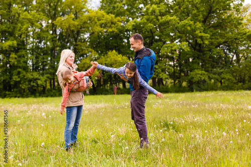 young familiy are walking through a green field