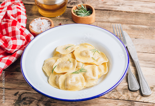Traditional italian ravioli with rosemary and parmesan served onon an enamel plates. Italian pasta.