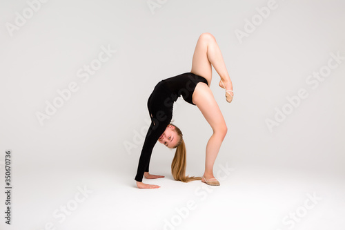 young beautiful girl gymnast on a white background. a young girl is engaged in gymnastics on a white background.