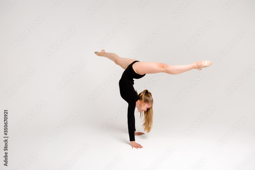 young beautiful girl gymnast on a white background. a young girl is engaged in gymnastics on a white background.