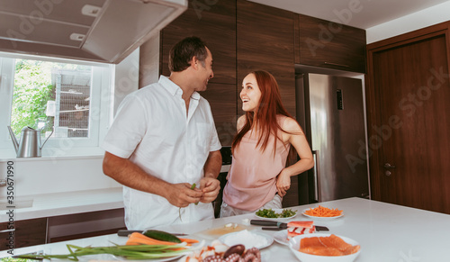 A couple  man and woman  cooking home sushi rolls laughing and having fun