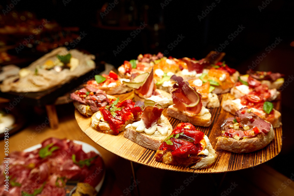 meat snacks on bread with vegetables on a buffet table
