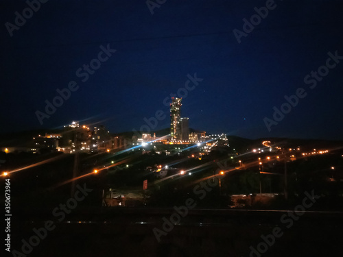 large cement factory, kind of at night, lamps are lit. © FOlga